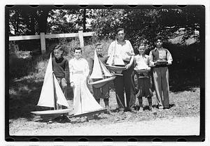 Boys holding model sailboats