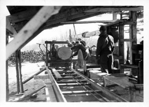 Putting Log on Carriage, Daniels Mills at Aggie Sawing the 1938 Hurricane Lumber. The School's Trees Were Sawed into 60,000 Feet. Neighboring Farmers Had 90,000 Feet Sawed Here.