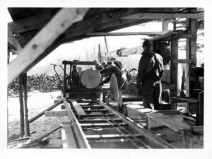 Putting Log on the Carriage - Daniels Mill at Aggie Sawing the 1938 Hurricane Lumber. The School's trees sawed into 60,000 Ft. Neighboring Farmers' Trees 90,000 Feet.