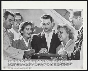 Series Hero Gets All Kinds of Chores--Center of a picture as Series winners start for home today just has to be the hero--and Larry Sherry, twice a pitching winner in four relief appearances, just has to autograph a junior-size bat. From left, Clem Labine, Don Drysdale, stewardess Lois Scheffler, Sherry, stewardess Flo Weber, and Norm Larker as Los Angeles Dodgers took plane for West Coast base.