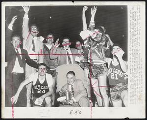 After Winning the Tournament -- Members of the Holy Cross team and exuberant fans gather around coach Buster Sheary who holds trophy after they defeated Duquesne, 71-62, to win the National Invitation Basketball Tournament at Madison Square Garden tonight. Player who are identifiable are Tom Heinsohn, 24, and Joe Early, 21.