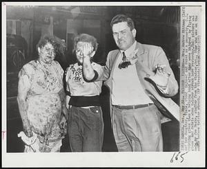 Twister Victims-- Mrs. Andrew Bittman (left) and her daughter, Viola, stand injured and dazed as a passerby, C.L. Stirling gives them a helping hand after they were injured by flying glass and debris when twister struck here yesterday. This picture was made by Joe Masko, staffer from the Windsor, Ont., Star who was on the scene before twister struck.