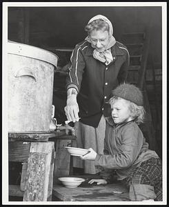 5 yr. old Marica Patriquin gets a sample of the newly made Vermont maple syrup from Mrs. Milton Fullerton of Top Acres - So. Woodstock, Vt.