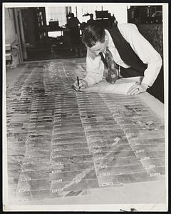 Aerial Map Making -- A Painstaking Job. Here the prints are laid out on a huge board to be matched together. Each is numbered so that it can be easily fitted into place. Note how straight the lines are. Previous to the use of the "polar navigator" it was often necessary to rephotograph many sections because the pilot had deviated so far from a straight line, that many of the photographs could not be fitted into the mosaic.