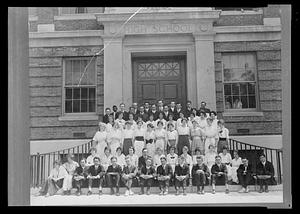 Unidentified high school class - 62 students on front steps of Natick High School (built in 1912), teacher on right, top row