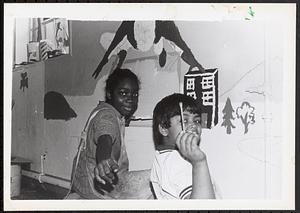 Girl and boy painting a mural on a wall