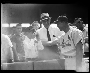 Young fan takes Stan Musial's picture as Comm. Ford Frick looks on