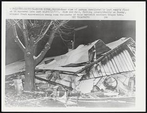 Rear view of garage demolished by last week's flood as it appeared late last night (12/27). Snow and rain, falling intermittently on Sunday, aroused fresh apprehension among some residents of this hard-hit southern Oregon town.