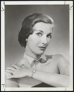 Dad’s wing collar was never like this, but there is little doubt that it was the inspiration for this unique pearl collar, designed to go with bare shoulders and strapless gowns. Made of woven pearls with a large rhinestone “collar button” in front, it has an adjustable back.