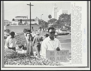 Postal workers carrying hand lettered signs picket in front of the main terminal annex post office in downtown Los Angeles early 3/23. In background (R) is Los Angeles City Hall. A post office official said the postal system was "experiencing no delays" in the Los Angels area despite heavy absences by workers at the terminal annex and Los Angeles International Airport. The spokesman said that because mail volumns are down, the skeletal crews at the strike bound centers may be able to handle the flow of mail normally.