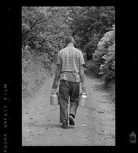 Farm boy carries milk cans down road, Monhegan Island, Maine