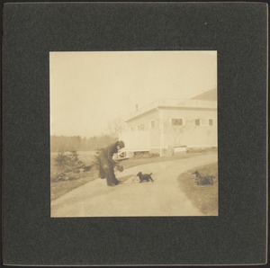 Ashdale Farm. Man with two dogs in yard near house. Print mounted on square black board.