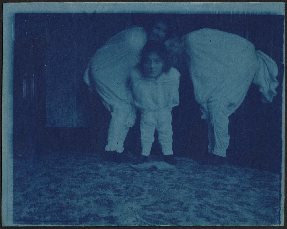 Abstract photo of three children (Isabel Stevens in middle) in white costumes, huddled together