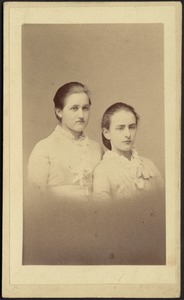 Two young woman in light colored frocks (head and shoulders)