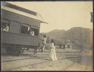 Train car on tracks, people boarding