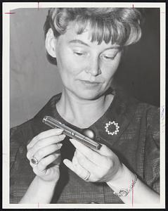 Tear Gas, gun of type being obtained by Greater Boston women in fear of mad strangler is displayed by Mrs. Mary Burns. The gun, approximately six inches long, resembles a fountain pen. Owners are instructed to aim it at chest or shoulders area of a would-be prowler or attacker.