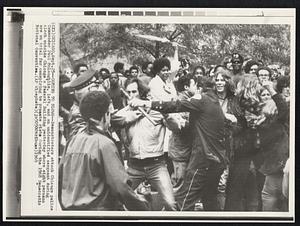 Coming to Blows--Demonstrators attack Chicago police Commander Paul McLaughlin, left, and a unidentified sergeant during clash outside Chicago's Federal Building yesterday were eight persons are on trial for conspiring to promote riots during the 1968 Democratic National Convention.
