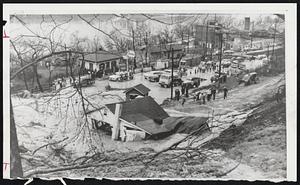Landslide Ties Up Traffic - Rocks and mud, loosened by heavy rain, engulf service station and block U. S. Rte. 52 near Ironton, Ohio, approach to Ohio River bridge (not shown) to Ashland, Ky. Landslide also threatened railway tracks across highway.