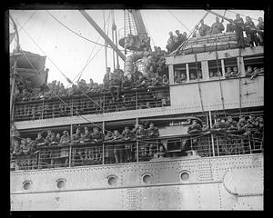 Soldiers looking out from the deck of a ship