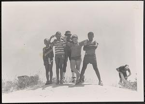 Five boys, including Seamus, Jamyel and Philip, standing and posing at the beach