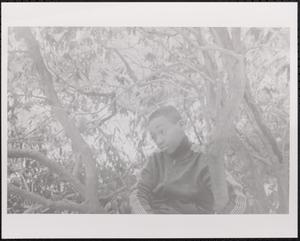 Boy sitting among the trees
