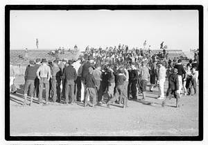 A crowd of people by bleachers