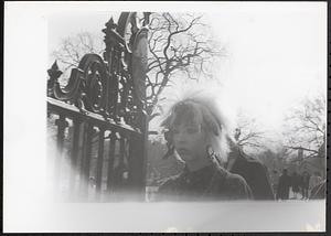 A woman walking past a gate