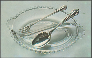 A glass dish with a fork and spoon