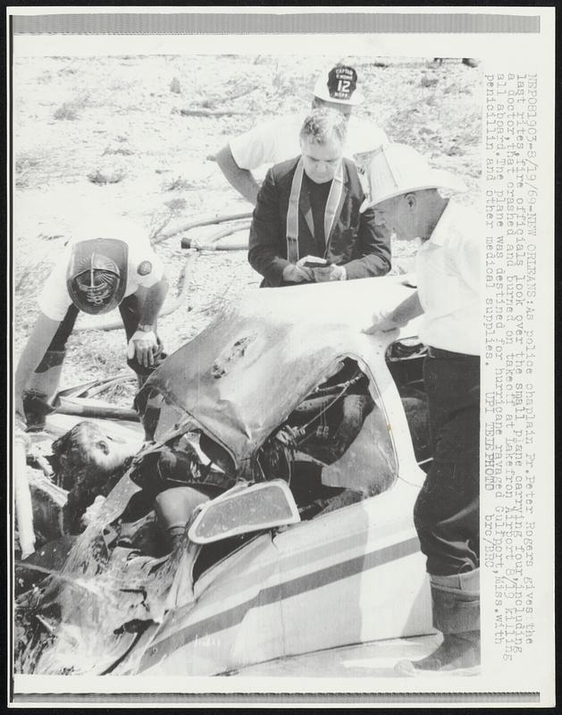 As police chaplain Fr. Peter Rogers gives the last rites, fire ...
