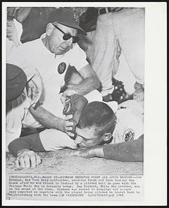 Hickman Receives First Aid After Beaning--Jim Hickman, New York Mets outfielder, receives first aid from trainer Gus Mauch after he was struck in thehead by a pitched ball in game with the Chicago White Sox in Sarasota today. Ray Herbert, White Sox pitcher, was on the mound at the time. Hickman was rushed to hospital but x-rays were reported as negative with the player being allowed to travel back to St. Petersburg with the team.