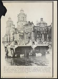 A couple of light tanks are shown parked in front of the Metropolitan Cathedral on the west side of Mexico City’s main square as another demonstration by students was reported to be brewing Wednesday. At least one person died and scores were injured in a series of riots by preparatory school students in the last two days.