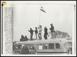 Anti-War Demonstrators Try "Stall-In" - Group of anti-war demonstrators stand atop bus in which they were traveling and wave peace flag as other demonstrators stopped their cars and blocked northbound traffic near Swedesboro, N.J., Sunday evening. Demonstrators moved on after about an hour but stopped again later near Camden, N.J., where some were arrested before traffic jam was broken up. Police were forced to close more than 25 miles of the pike for four hours.