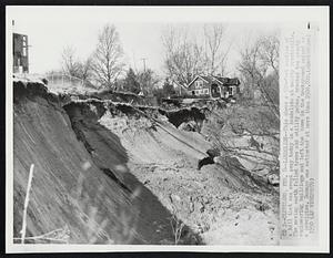 Landslide--This shows a 500-foot section of a hill that was swept away today in a landslide at nearby Brecksville. The moving earth felled trees and utility poles, wrecked two county engineering buildings and left the home in the background pointed on a precipice. Damage was estimated at more than $500,000.