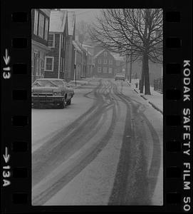 Tire tracks in snow covered street