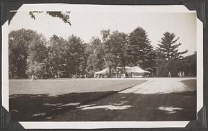 A tent set up by trees, a path in the foreground