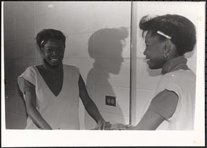 Young woman smiling in front of a mirror