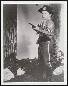 Corporal Rusty (Lee Aaker) stands ready to challenge an unknown intruder near Fort Apache in this dramatic scene from The Adventures of Rin Tin Tin, Friday at _ PM on Channel _ and the ABC Television Network.