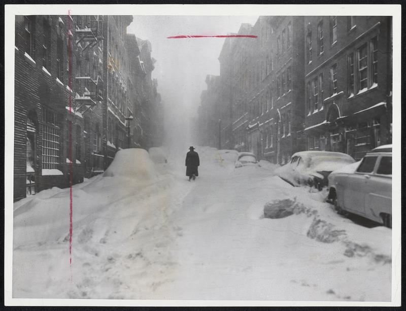 Never Miss My Afternoon Walk - A stern-stuff Bostonian strolls past abandoned cars on Philips street on Beacon Hill, which he had all to himself at this point in the storm.