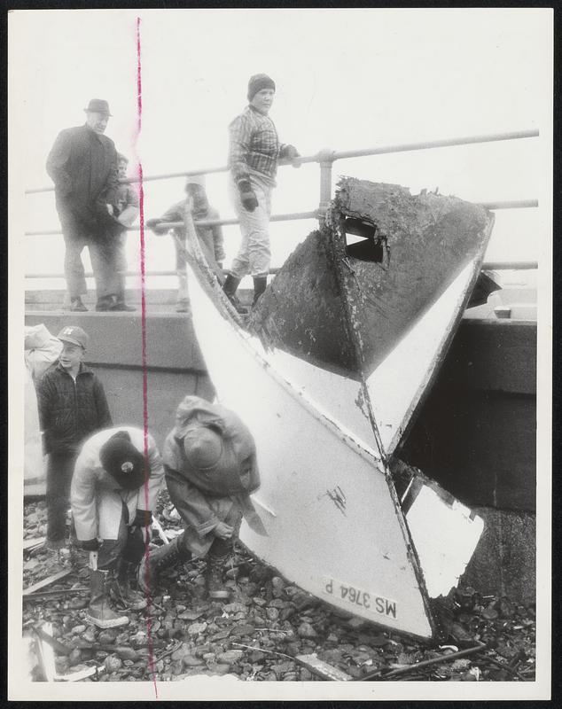 Boys examine bow of wrecked boat.