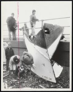 Boys examine bow of wrecked boat.