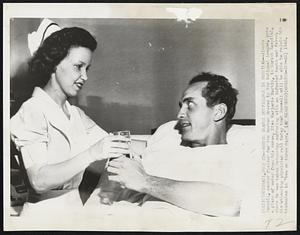 Boston Braves Outfielder in Hospital - Jimmie Russell, center fielder for the Boston Braves in the National League, gets a glass of water from his nurse, Miss Marjorie Martin, in Christ hospital, where he was taken Wednesday suffering with an infected tooth and fever. His attending physician said today that Russell will be able to rejoin his teammates in "two or three days."