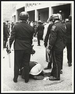 Policemen surround a person who is showing their buttocks
