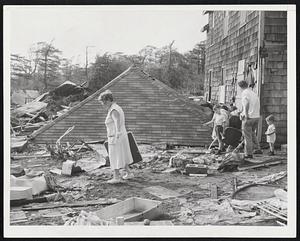 Family Seeks Remnants of Belongings in hurricane debris at Mattapoisett. Behind woman is the displaced roof of somebody's home.