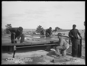 Distribution Department, Southern High Service Forbes Hill Reservoir, riveting the base of Standpipe by compressed air, Quincy, Mass., Oct. 19, 1900