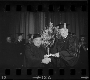 John E. Powers is presented his degree in law by Suffolk University Pres. Judge John Fenton during commencement