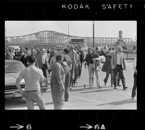 Construction workers watch demonstrators returning to South Station after they picketed the gates to the Boston Army Base