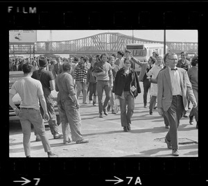 Construction workers watch demonstrators returning to South Station after they picketed the gates to the Boston Army Base