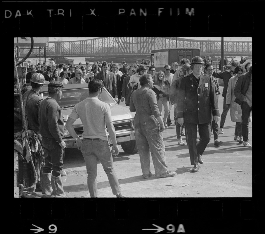 Construction workers watch demonstrators returning to South Station after they picketed the gates to the Boston Army Base