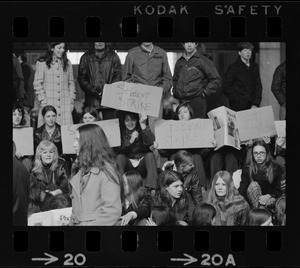 Boston high school students sit on steps at City Hall to display their strike signs during demonstration on City Hall Plaza