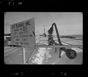 BP Alaska oil pipe, derrick in background, sign in foreground